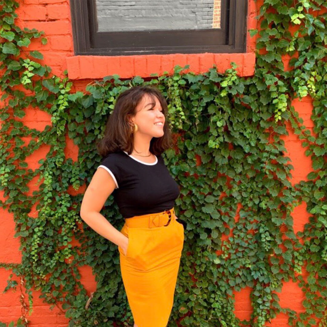 Sophie Gengler standing in front of a red brick wall with ivy